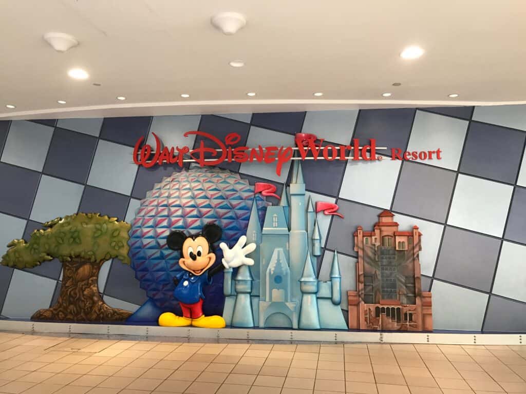 Mickey Mouse, Disney World Resort logo, and park icons brighten a hallway mural, capturing classic Disney magic for fans.