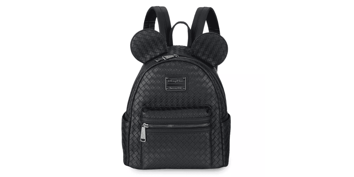 A stylish black backpack featuring a quilted pattern and two large, round, mouse ear-like shapes on the top. It has a front zippered pocket and adjustable shoulder straps.