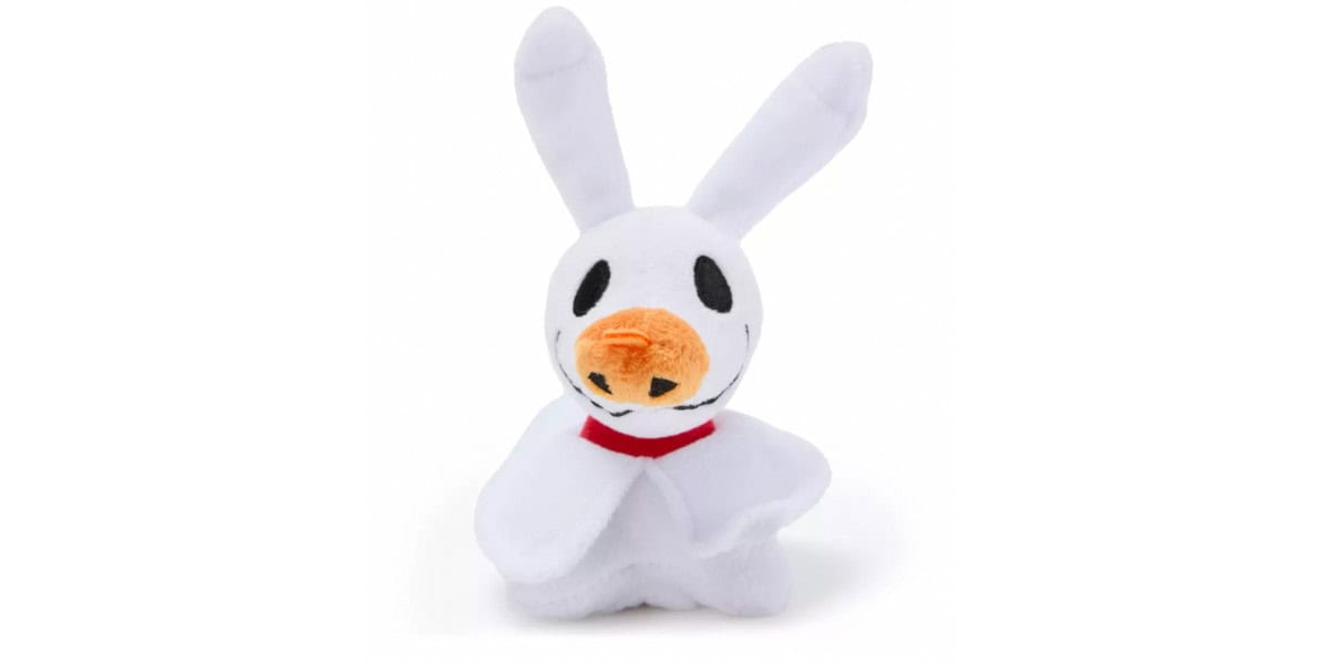A plush toy resembling Zero, the ghost dog from "The Nightmare Before Christmas," with a white body, floppy ears, a red collar, and a pumpkin-shaped nose.
