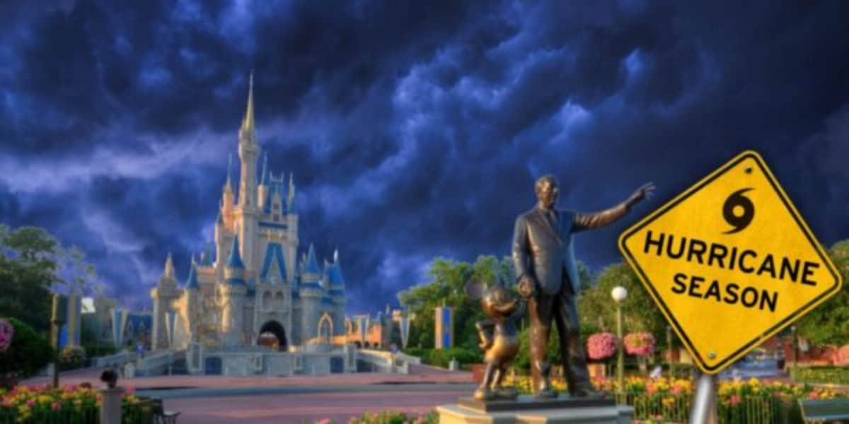 A dramatic stormy sky looms over a Disney World castle with a statue of Walt Disney holding Mickey Mouse's hand in the foreground. A yellow warning sign with a hurricane symbol reads "Hurricane Season." The scene blends iconic imagery with an urgent reminder to prepare for the impending weather.