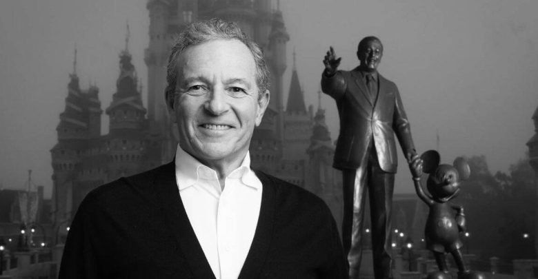 Disney fan beams with excitement in front of Cinderella Castle and iconic Walt & Mickey statue during 2023 Disney news reveal.