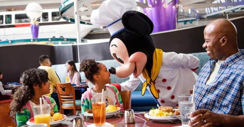 A family meets a Disney character cast member dressed as Mickey Mouse at Chef Mickey's