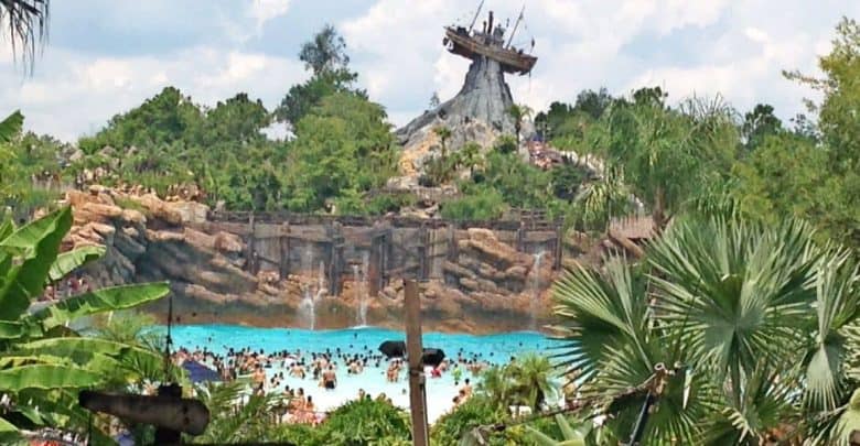 Disney’s Typhoon Lagoon wave pool buzzes with guests, lush landscaping, and a mountain shipwreck—despite closures elsewhere.