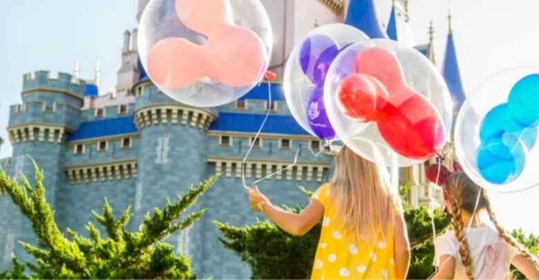guests holds mickey-shaped balloons in front of cinderella castle in disney world's magic kingdom park. Disney World incident