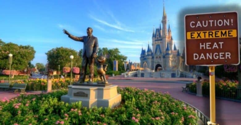 Extreme heat advisory sign by a statue and Cinderella Castle at Disney World, warning guests some rides may close on hot, sunny days.