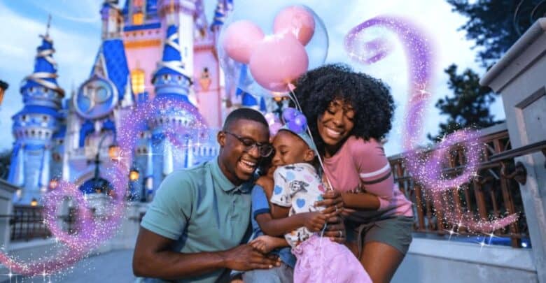 A family beams and embraces in front of Cinderella Castle at Disney World, holding pink Mickey Mouse balloons.
