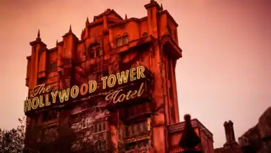 The Hollywood Tower Hotel glows with neon as twilight falls, capturing the eerie thrill of Disney's Tower of Terror at sunset.