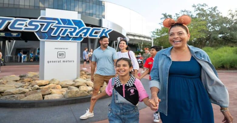 Family enjoying a sunny day, walking hand-in-hand outside Epcot’s Test Track at Walt Disney World Resort in Orlando.