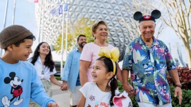a Disney family strolls through EPCOT with Spaceship Earth in the background