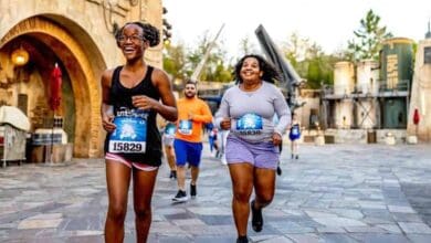 Two runners smiling at the 2027 runDisney Wine & Dine race in Star Wars: Galaxy’s Edge at Disney’s Hollywood Studios.