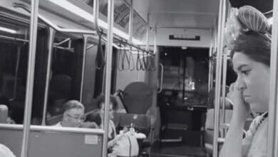 Guest wearing Mickey Mouse ears riding a Disney World bus.