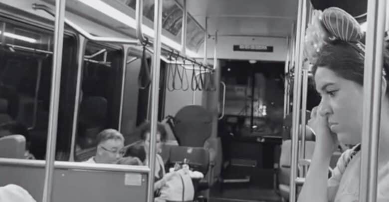 Guest wearing Mickey Mouse ears riding a Disney World bus.