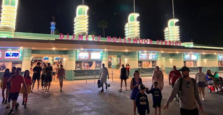 Guests heading toward the entrance of Disney’s Hollywood Studios at night.