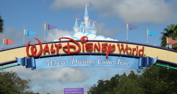 Walt Disney World entrance sign with a castle and "Where Dreams Come True" slogan under a blue sky, welcoming fans to the magic.