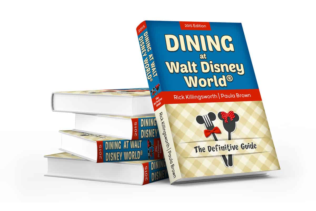 Stack of "Dining at Walt Disney World: The Definitive Guide" books with blue and beige covers, perfect for devoted Disney fans.