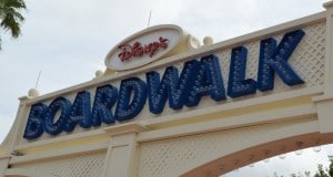 Disney’s BoardWalk sign in blue letters, glowing with lights on a white arch, greets guests at this lively Walt Disney World hotspot.