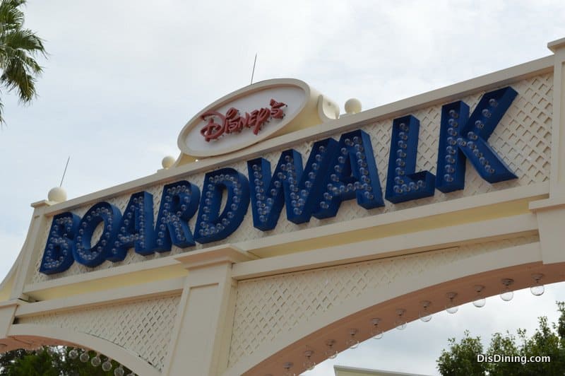 Disney’s BoardWalk sign in blue letters, glowing with lights on a white arch, greets guests at this lively Walt Disney World hotspot.