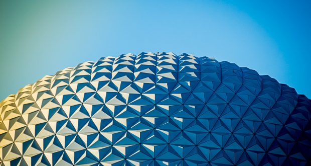 Epcot’s gleaming geodesic dome sparkles in the sun under a bright blue sky, evoking the magic of Disney’s iconic park.