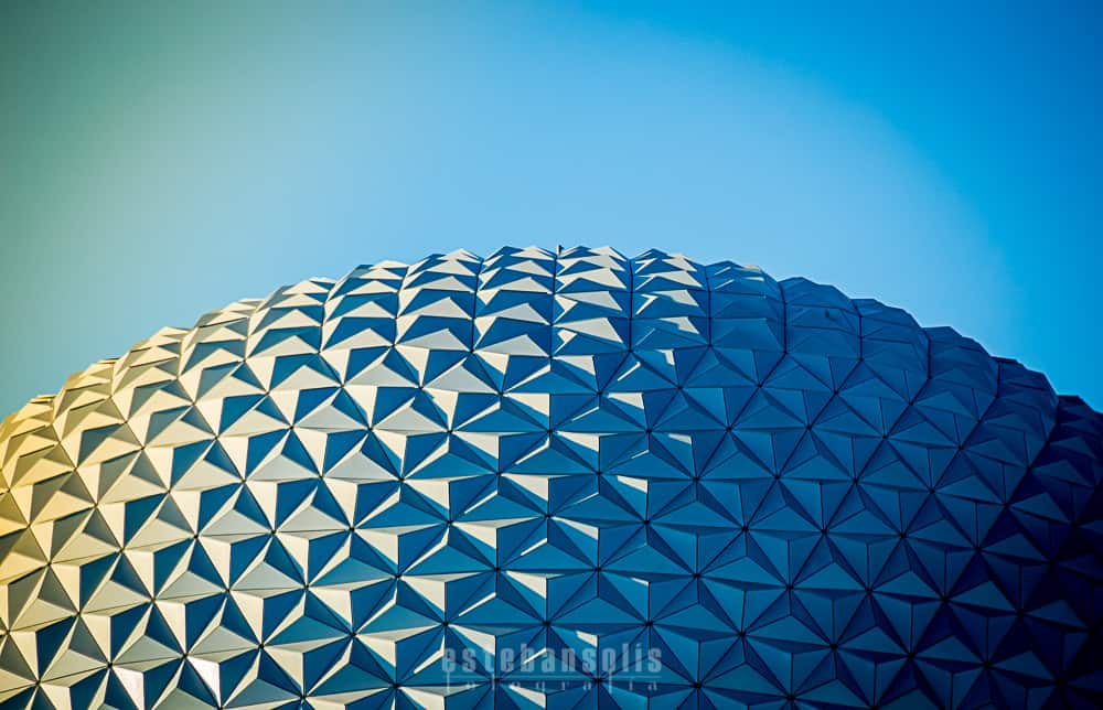 Epcot’s gleaming geodesic dome sparkles in the sun under a bright blue sky, evoking the magic of Disney’s iconic park.