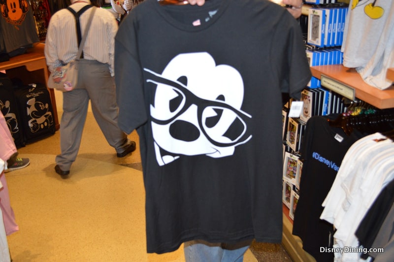 Black tee featuring Mickey Mouse in bold black glasses—ideal park merch for fans hitting Disney World or Disneyland this season.