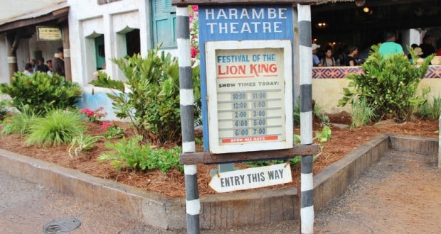 Harambe Theatre sign at Disney's Animal Kingdom shows "Festival of The Lion King" showtimes and an "Entry This Way" arrow.