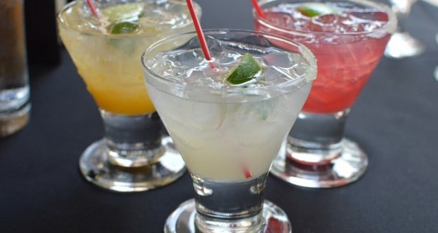 A trio of colorful cocktails with lime wedges and red straws—cheers to adults-only fun at Disney World!.
