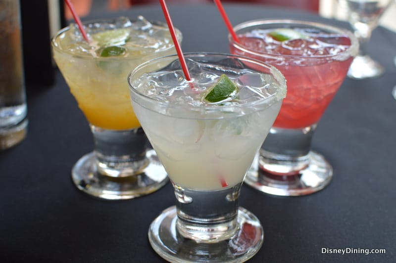 A trio of colorful cocktails with lime wedges and red straws—cheers to adults-only fun at Disney World!.