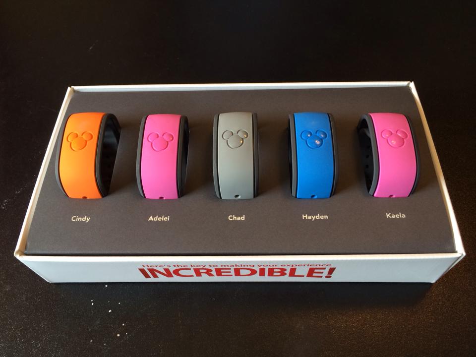 Five vibrant MagicBands labeled Cindy, Adelei, Chad, Hayden, and Kaela await in a box—ready for Disney World fun!.