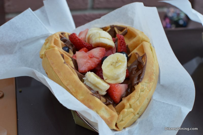 A heart-shaped waffle with Nutella, bananas, and strawberries—just like a sweet treat from Main Street at Disney Parks.