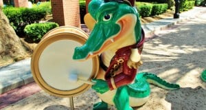 Louis the alligator from The Princess and the Frog drums in his vibrant marching band uniform at Disney’s Port Orleans–French Quarter.