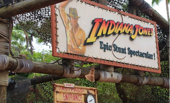 Indiana Jones Epic Stunt Spectacular entrance with Indy on the sign and a Fastpass lane, welcoming fans at Disney’s Hollywood Studios.
