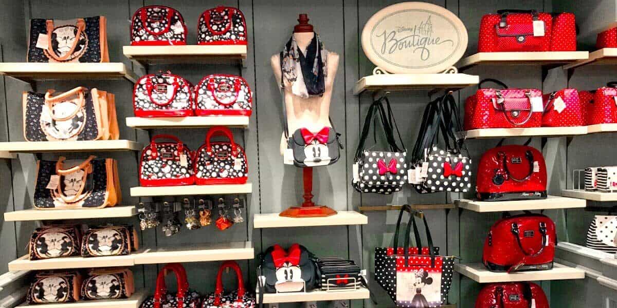 Minnie Mouse-inspired purses, bags, and wallets in classic red, black, and polka dot styles line the display shelves at Disney World.