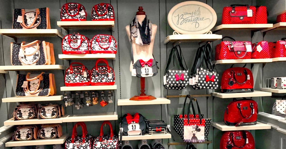 Minnie Mouse-inspired purses, bags, and wallets in classic red, black, and polka dot styles line the display shelves at Disney World.
