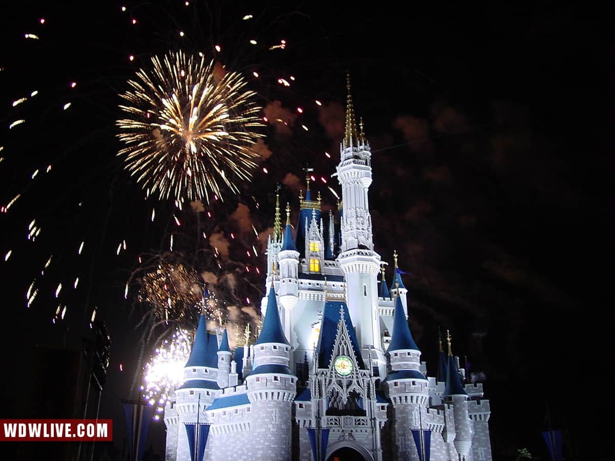 Cinderella Castle at Disney World sparkles under a night sky as vibrant fireworks light up the park for guests.