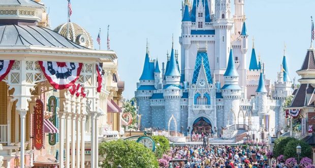 Crowds in front of The Emporium and Cinderella Castle on Magic Kingdom Park's Main Street, U.S.A.