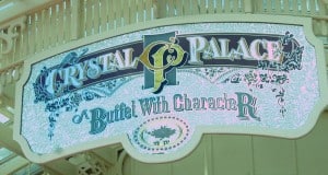 Crystal Palace Buffet With Character sign, adorned with whimsical patterns and a tree emblem, welcomes guests at Magic Kingdom.