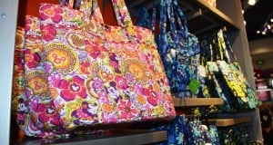 Tote bags with Disney floral and character prints line the shelves—ideal accessories for your next trip to Walt Disney World.