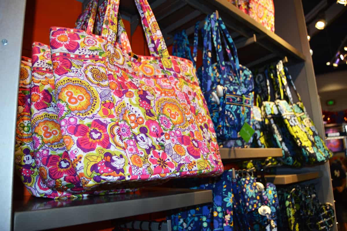 Tote bags with Disney floral and character prints line the shelves—ideal accessories for your next trip to Walt Disney World.