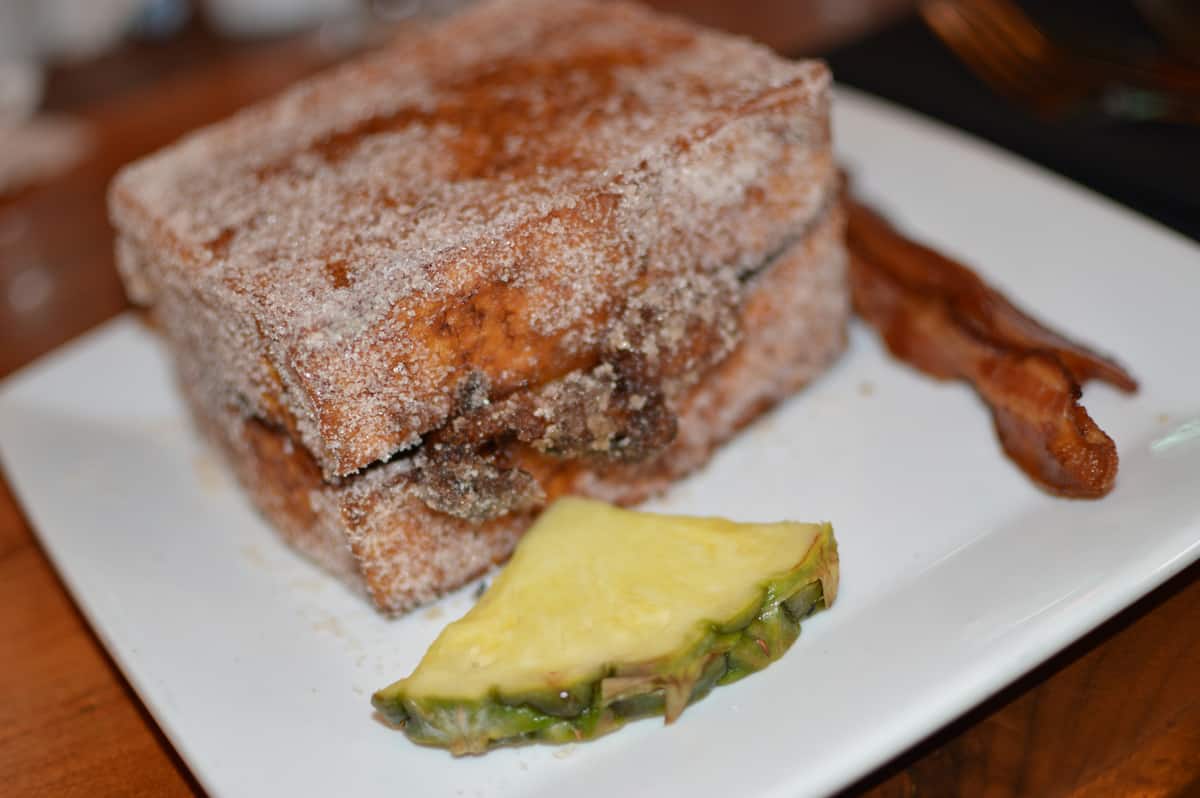 French toast dusted with sugar, pineapple, and crispy bacon at Kona Café—savor this fan-favorite Disney World breakfast!.