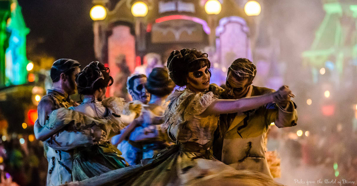 Zombie-costumed dancers waltz through a vibrant Halloween parade at Walt Disney World, capturing its iconic spooky spectacle.