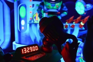 Buzz Lightyear’s blaster glows with a 132900 score, set against cosmic backdrops in Tomorrowland at Magic Kingdom.