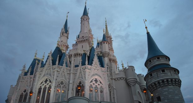Cinderella Castle with blue spires and intricate details shines at dusk, showcasing the magic of Magic Kingdom at Walt Disney World.