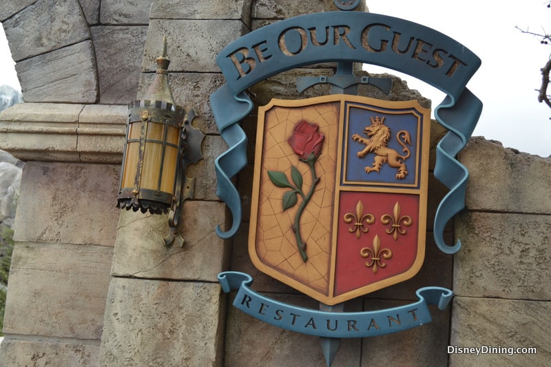 Be Our Guest Restaurant sign with a rose, lion, and fleur-de-lis shield—one of Walt Disney World's top dining experiences.