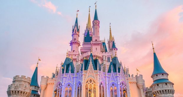 Cinderella Castle glows with blue spires and gold accents as the sun sets, radiating Disney World’s iconic magic and wonder.