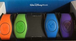 Five vibrant Disney MagicBands in a box, Walt Disney World branding behind—your key to seamless park entry and magical ease.