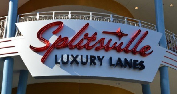 A sign with red and black text reads "Splitsville Luxury Lanes" on the exterior of a building, with blue columns and a curved white balcony above.