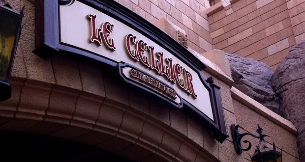 Le Cellier Steakhouse entrance sign at EPCOT, framed by stone and brick, with glowing lanterns—an iconic Disney dining spot.
