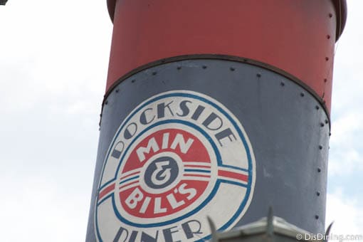 The iconic Dockside Diner Min & Bill's sign atop a red and blue structure welcomes guests at Disney’s Hollywood Studios.