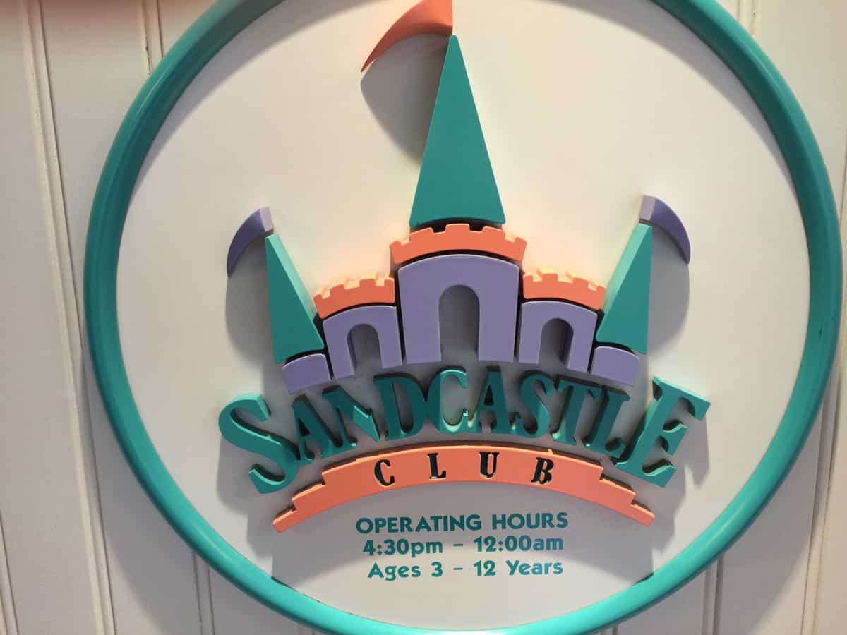 Sandcastle Club sign featuring a castle logo and hours for kids 3–12, promising magical childcare fun at Walt Disney World.