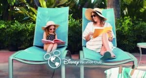 A woman and a young girl relax on turquoise lounge chairs outdoors, both wearing sunglasses and sun hats. The woman reads a book on Disney Vacation Club pros and cons and smiles at the girl, who looks at a picture book. Disney Vacation Club logo is overlaid.
